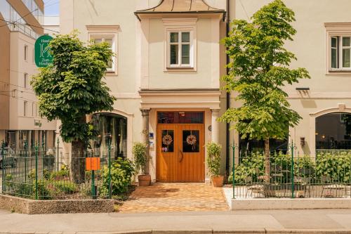 a house with a wooden door on a street at Design Hotel zum Hirschen Salzburg in Salzburg