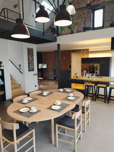 a dining room with a table and chairs and a kitchen at Gîte La Siroperie in Wanze