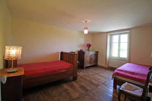 a bedroom with two beds and a window and a table at Boissac in Le Vigen