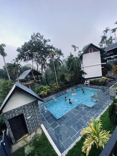 an overhead view of a swimming pool with people in it at Wild Nest Resort, Wayanad in Meppādi