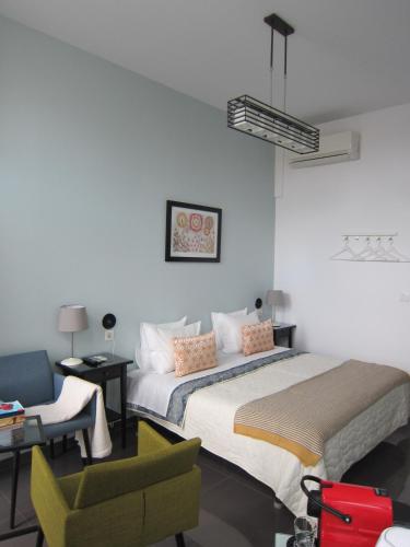 a bedroom with a large bed and a chair at Pinho Apartments, Studios and Rooms in Porto