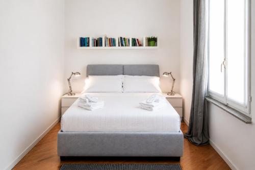 a bedroom with a bed with two lamps and a window at Vittorio Emanuele Apartment - Downtown Como in Como