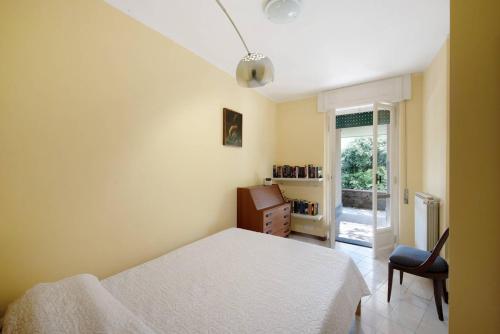a bedroom with a bed and a chair and a window at Villa Roberta Pool, wifi & Parking in Arenzano