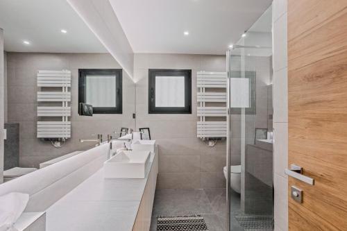 a bathroom with two sinks and a shower at Les Oliviers De Lunéa in Fayence
