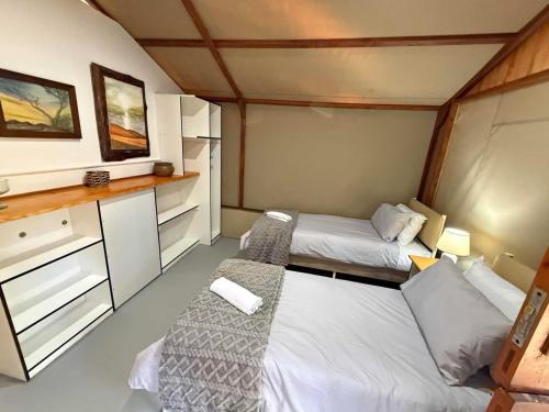 a small room with two beds and a counter at Kholiwe 1 - 4 sleeper glamping in a forest in Port Edward