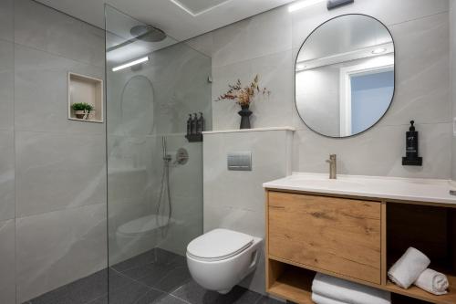 ein Badezimmer mit Toilette, Waschbecken und Spiegel in der Unterkunft Tzuba Hotel in Ẕova