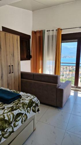 a bedroom with a bed and a couch and a window at Kotor Bay View Apartments in Bijela