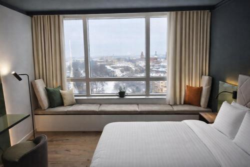 a bedroom with a bed and a large window at Holiday Inn Cottbus by IHG in Cottbus