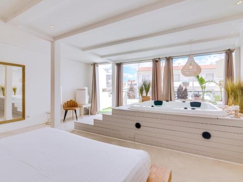 a bedroom with a tub with a large window at Villa Monica with Private Pool and Jacuzzi in Quarteira