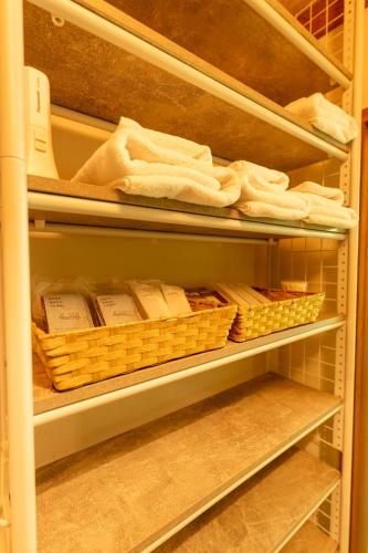 a refrigerator filled with lots of towels and baskets at 1日1組様限定 最大10名様 キャンプ 温泉付き Villa 水と深緑 in Azumino