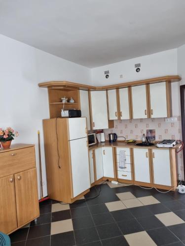 a kitchen with wooden cabinets and a white refrigerator at Kłączyn in Kłaczno
