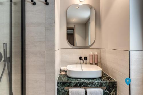 a bathroom with a sink and a mirror at TriplyRooms Collection - Roma Prassede in Rome