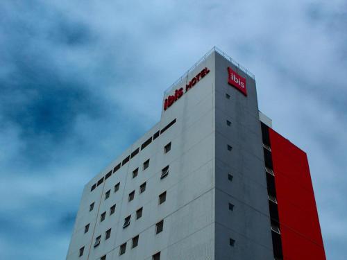 a building with a red sign on top of it at ibis Natal in Natal