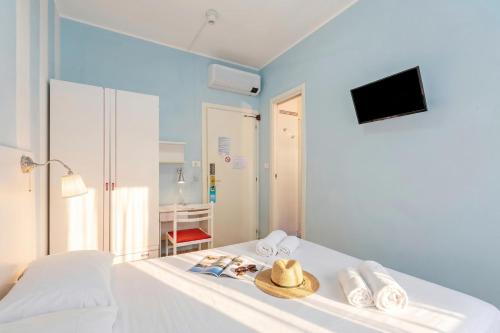 a bedroom with a white bed with a hat on it at Hotel Del Golfo in Laigueglia