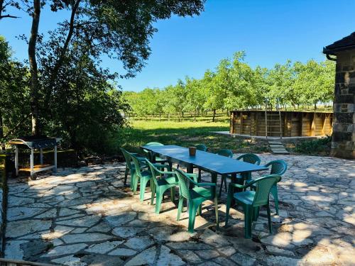 a table and chairs on a stone patio at Gîte La Chaumière avec Piscine in Nailhac