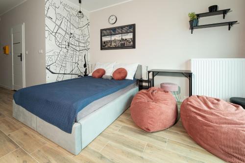 a bedroom with a bed and two ottomans at Sky tower space in Katowice