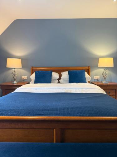 a bedroom with a bed with blue sheets and two lamps at The Nook County Dublin in Dublin