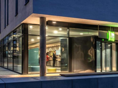 a store front of a building with people in the window at ibis Styles Stuttgart Vaihingen in Stuttgart