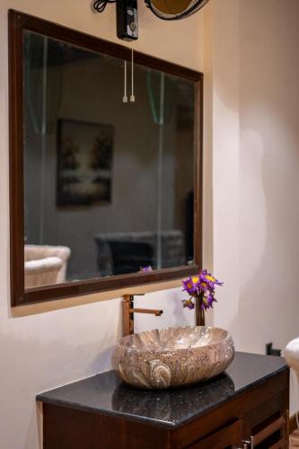 a bathroom sink with a large mirror on a table at Beverly Hills Retreat in Kandilpana