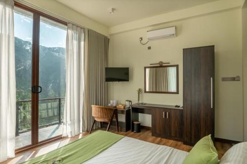 a bedroom with a bed and a desk and a window at Beverly Hills Retreat in Kandilpana
