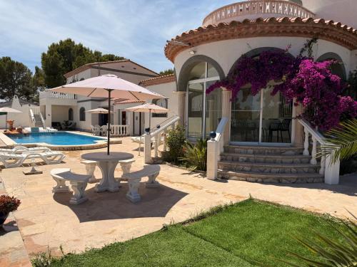a house with a table and chairs and a pool at Amarella Costa Dorada - Alojamientos privados en villa mediterránea con amplia piscina y zonas BBQ in Les tres Cales