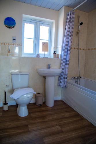a bathroom with a toilet and a sink and a tub at Luxury 2 Bedroom serviced accommodation in Solihull