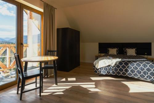 a bedroom with a bed and a table and a window at Widokówka in Wetlina