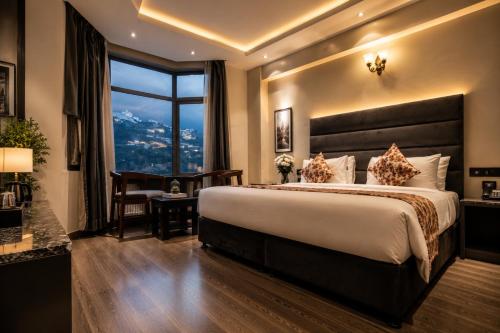 a hotel room with a large bed and a window at Click Sunburry Hotel Katra in Katra