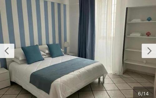 a bedroom with a bed with blue and white stripes at Casa Annacarla in Noci