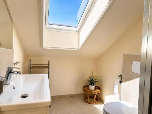 a bathroom with a sink and a skylight at Apartment House with Shared Pool in Premantura