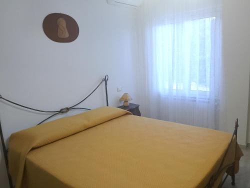 a bedroom with a yellow bed with a window at Casa Amica Termoli 1 in Termoli
