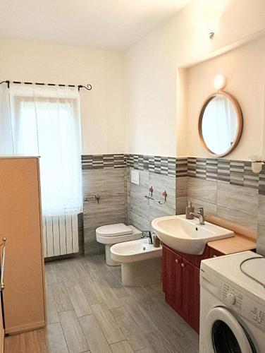 a bathroom with a sink and a toilet and a mirror at Casa Amica Termoli 1 in Termoli