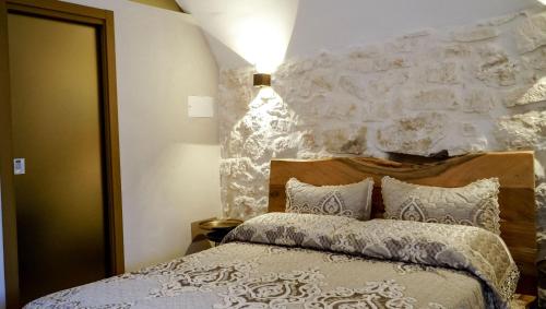 a bedroom with a bed with a stone wall at Borgo Pascarosa in Ostuni