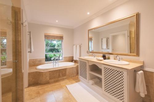a bathroom with two sinks and a large mirror at Last Word Constantia in Cape Town