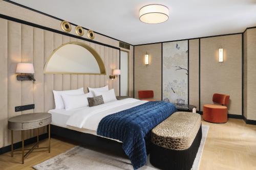 a bedroom with a large bed with a blue blanket at Hotel Experior Boutique - Destigo Hotels in Krakow