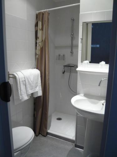 une salle de bain avec un lavabo, des toilettes et une douche dans l'établissement Hôtel Restaurant Les Touristes, à Vals-les-Bains