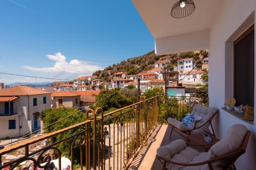 a balcony with chairs and a view of a city at Lenaki House in Ayía Kiriakí