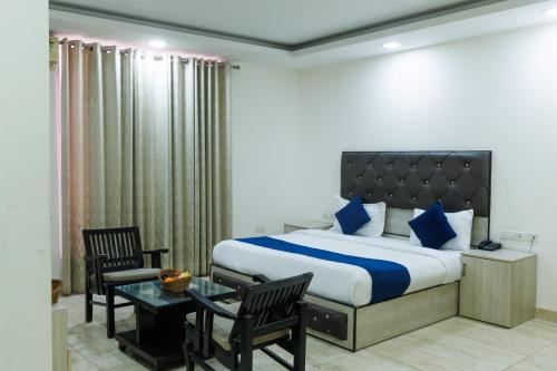 a bedroom with a bed and a table and chairs at Hotel Ornate Residency And Suites in Gurgaon