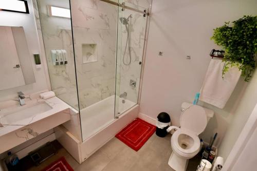 a bathroom with a shower and a toilet and a sink at The Modern Suite - 2BR Close to NYC in Paterson