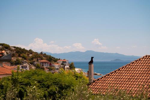 a view of a town with houses and the ocean at Lenaki House in Ayía Kiriakí