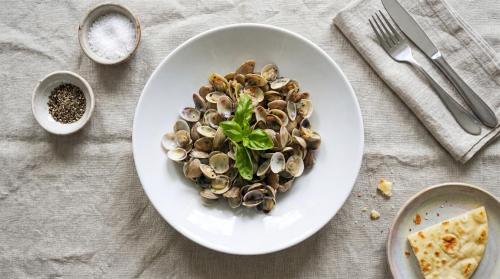a white plate of food with mushrooms on a table at Brasilia Sweet Home in Cesenatico