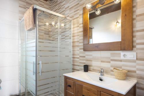 a bathroom with a sink and a glass shower at Casa El Duque Zaira in Vejer de la Frontera