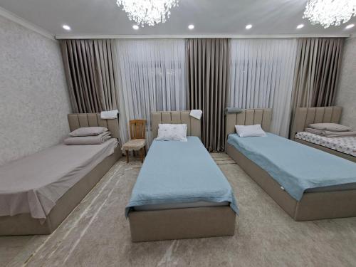 a hospital room with two beds and a chandelier at Guest house USMAN in Kazarman