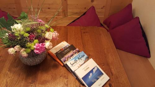 a table with two books and a vase of flowers at Parseierblick in Sankt Anton am Arlberg