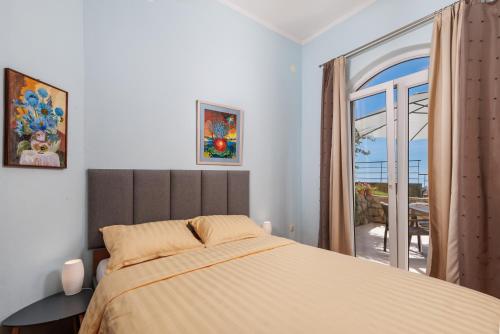a bedroom with a bed and a large window at Apartments Bellavista in Matulji