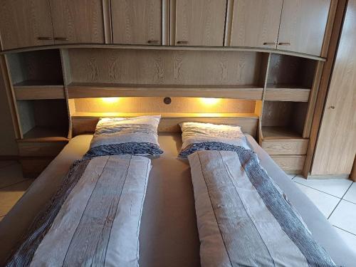 two beds in a small room with wooden cabinets at Ferienwohnung Talblick in Horath