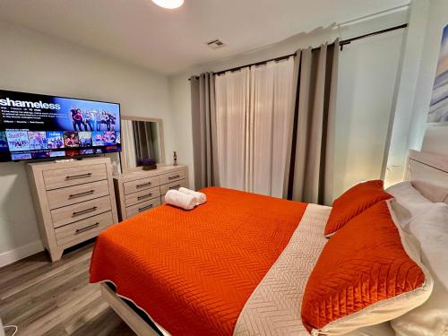 a bedroom with a bed and a flat screen tv at The Stylish Suite - 1BR with Free Parking in Paterson