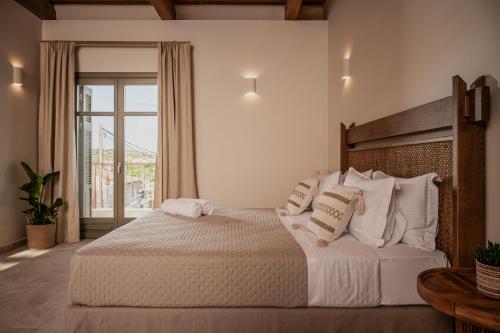 a bedroom with a large bed with white sheets and pillows at JUNO Collection Residences in Pythagoreio