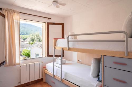 a bedroom with two bunk beds and a window at Majordoms Art in Sant Feliu de Pallerols