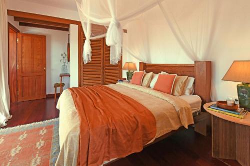 a bedroom with a large bed with orange sheets at Casa San Luis in Pájara